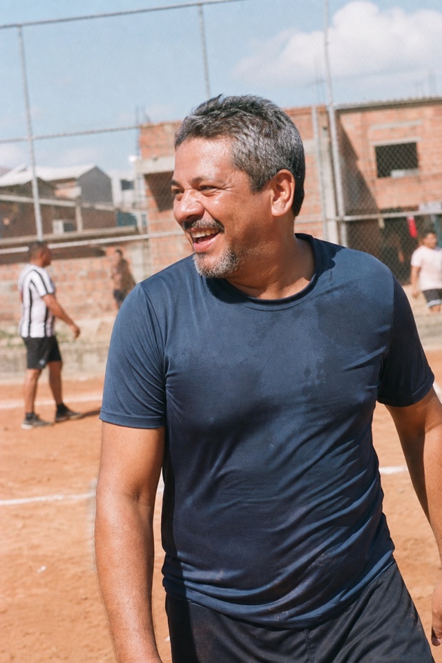 Lucas joga futebol e olha para um companheiro à esquerda.