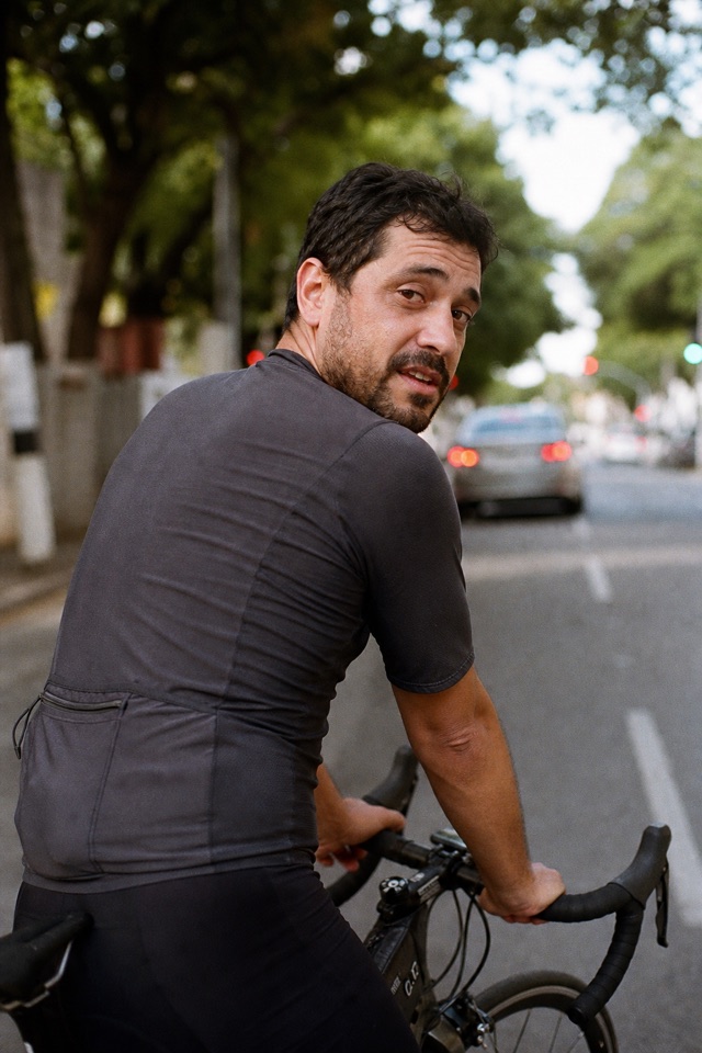 Rafael olha por cima do ombro enquanto pedala em Belo Horizonte.